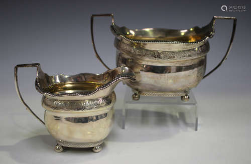 A George III silver two-handled sugar bowl of cushion form with engraved anthemion band, on bun