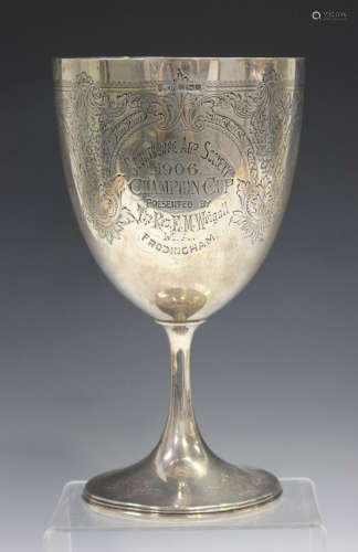 An Edwardian silver trophy cup, the U-shaped body with foliate engraved decoration and
