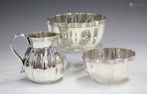 An Edwardian silver milk jug and matching pair of graduated sugar bowls, each of shaped circular