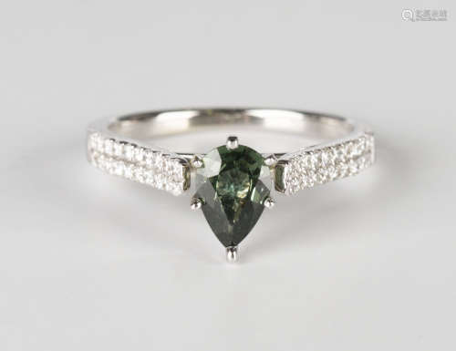 A white gold, green sapphire and diamond ring, claw set with a pear shaped green sapphire between
