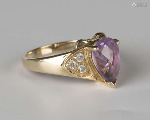 A 9ct gold ring, mounted with a pear shaped amethyst between circular cut diamond set three stone