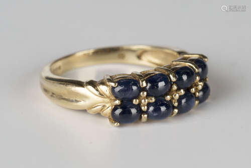 A 9ct gold ring, mounted with two rows of four oval cabochon sapphires, detailed '9K', ring size