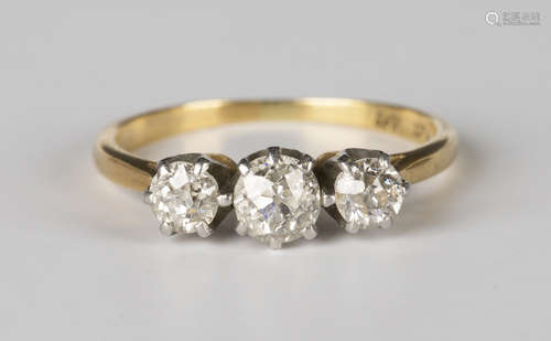 A gold, platinum and diamond three stone ring, claw set with a row of cushion cut diamonds, detailed