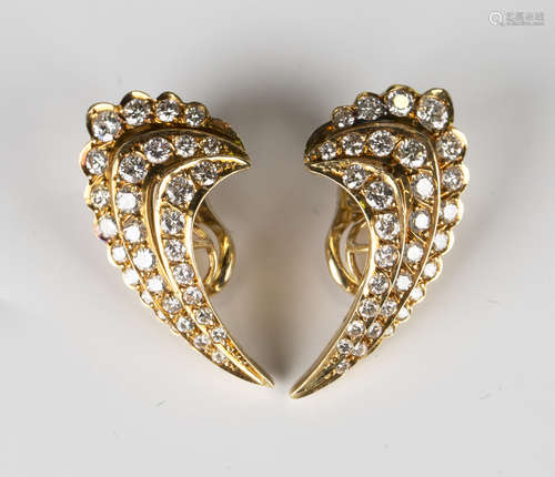 A pair of gold and diamond earclips in a curved three row design, each row mounted with graduated