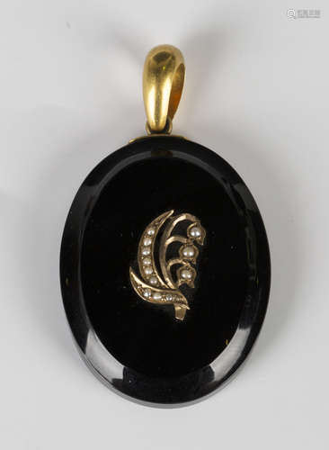 A Victorian gold mounted oval black onyx pendant mourning locket, the front with a seed pearl set