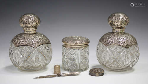 A pair of Edwardian silver mounted cut glass perfume bottles, the collars and screw tops embossed