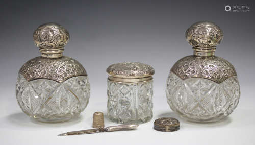 A pair of Edwardian silver mounted cut glass perfume bottles, the collars and screw tops embossed