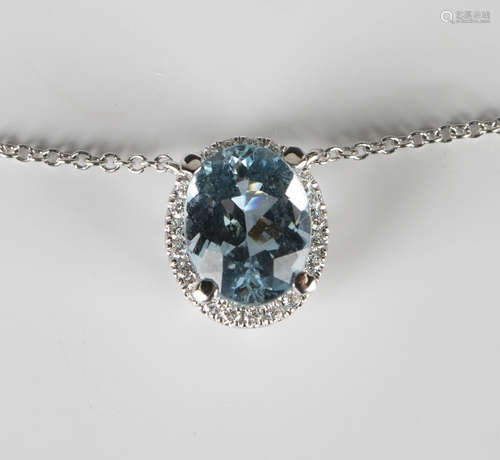 A white gold, aquamarine and diamond pendant necklace, claw set with an oval cut aquamarine within a