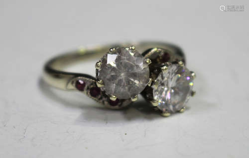 A 9ct white gold and colourless gem set two stone ring in a twist-over design, a silver and carved