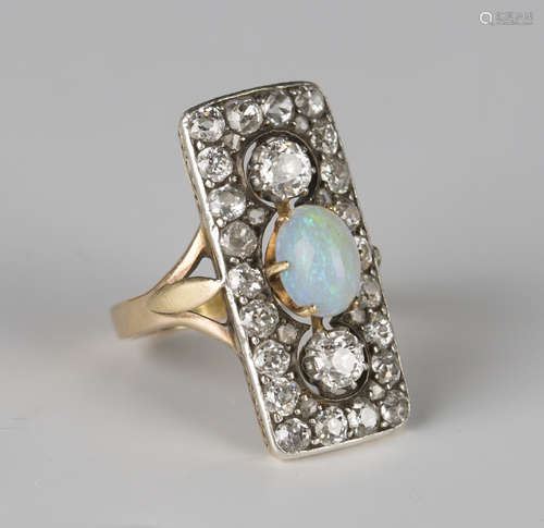 A gold, opal and diamond panel shaped ring, the centre claw set with an oval opal between two