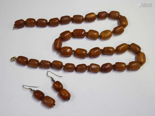 A single row necklace of vari-coloured opaque graduated barrel shaped butterscotch coloured amber