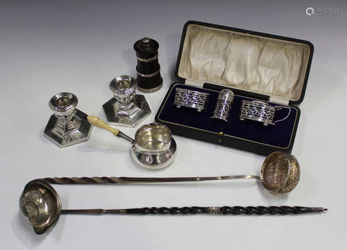 A George V silver three-piece condiment set, Birmingham 1924, cased, two silver punch ladles with