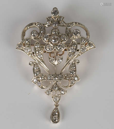 A diamond brooch in a scroll pierced design, mounted with cushion cut diamonds, the front with a