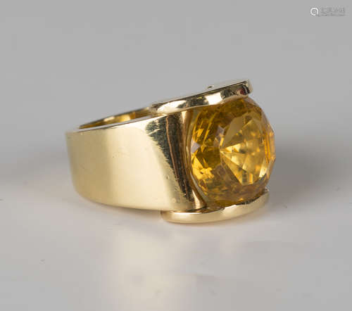 A French 18ct gold and citrine wide band ring, mounted with a circular cut citrine between half-