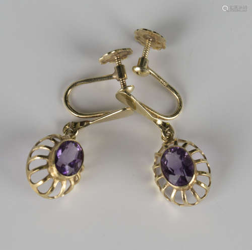 A pair of gold and amethyst single stone earrings, each collet set with an oval cut amethyst