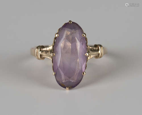 A gold ring, claw set with an oval cut amethyst, detailed '18K', ring size approx R.Buyer’s