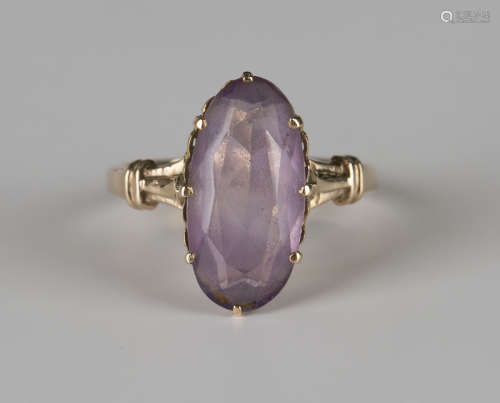 A gold ring, claw set with an oval cut amethyst, detailed '18K', ring size approx R.Buyer’s