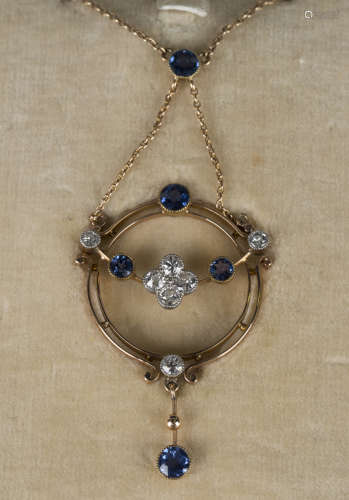 A gold, diamond and sapphire pendant necklace, circa 1910, in a circular openwork design, mounted