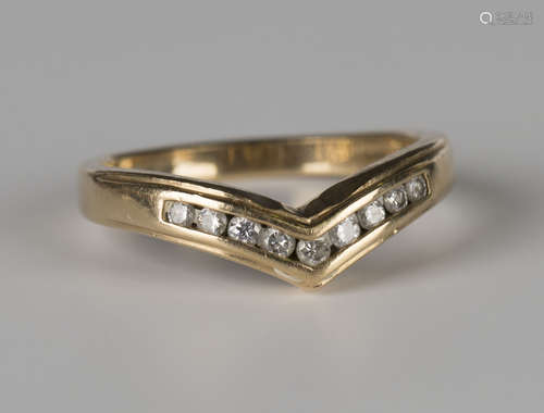 A 9ct gold and diamond set wishbone shaped ring, mounted with a row of nine circular cut diamonds,