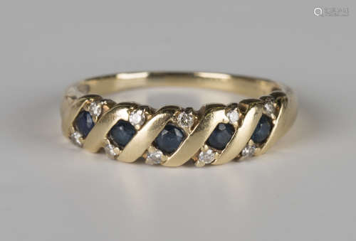 A gold, sapphire and diamond ring, mounted with a row of five circular cut sapphires with pairs of