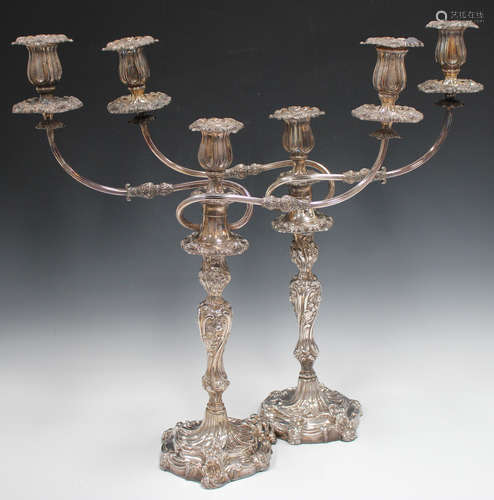 A pair of George III silver candlesticks, each rococo scroll moulded baluster stem decorated in