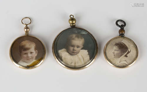 A 9ct gold mounted circular pendant locket, glazed to the back and front with photographic