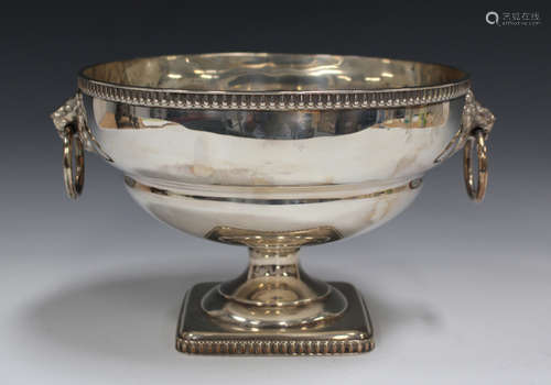 A George V silver circular fruit bowl with egg and dart rim above a pair of lion mask and loose ring