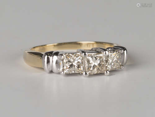 A gold and diamond three stone ring, mounted with a row of princess cut diamonds, the principal