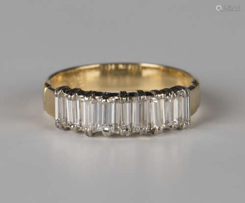 A gold and diamond half-hoop ring, mounted with a row of nine baguette diamonds, detailed '18ct',