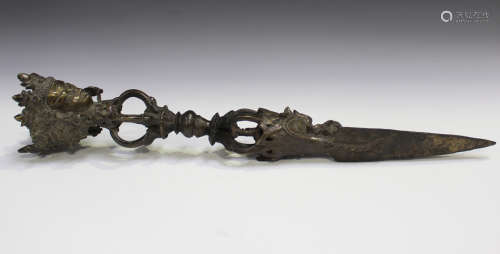 A Tibetan brown patinated bronze phurba, probably late 19th/early 20th century, the handle cast with