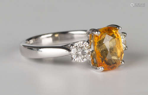 A white gold, intense yellow sapphire and diamond ring, claw set with an oval cut intense yellow