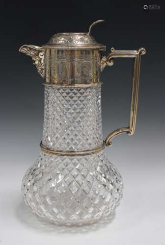 A late Victorian silver mounted cut glass claret jug, the low-bellied body with silver collar,
