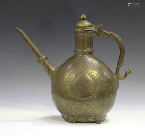 An Islamic bronze teapot, 19th century, the ovoid body with engraved decoration beneath a domed