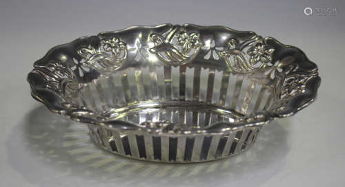 An Art Nouveau silver oval basket with pierced sides and embossed flowers and sinuous stems,