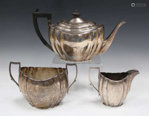 A late Victorian silver three-piece tea set of lobed oval form, comprising teapot, two-handled sugar