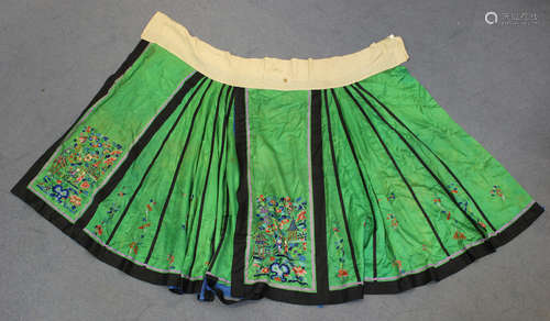 A Chinese green silk embroidered apron skirt, early 20th century, worked in coloured threads with