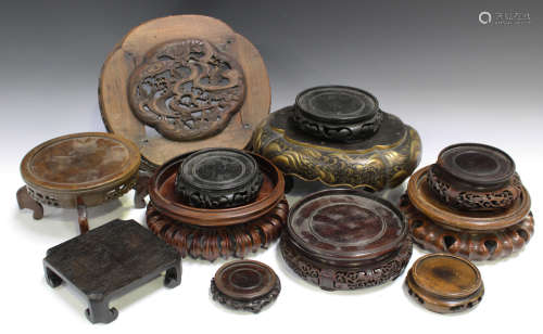 A collection of ten Chinese wood stands, 19th and 20th century, the majority with carved and pierced