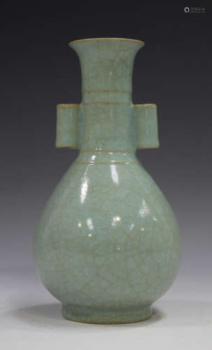 A Chinese celadon glazed bottle vase, the pear form body beneath a narrow neck and tubular