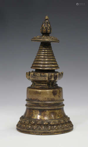 A Tibetan bronze stupa, possibly 15th/16th century, of bell form with foliate finial above a spire