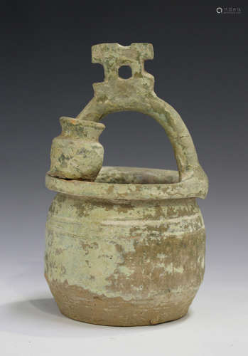 A Chinese terracotta pot, probably Tang dynasty, the circular body with overhead handle and