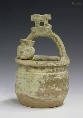 A Chinese terracotta pot, probably Tang dynasty, the circular body with overhead handle and