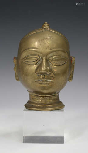 An Indian bronze head of a deity, 18th/19th century, modelled with eyes closed, height 11cm.Buyer’