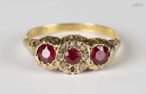 An Edwardian 18ct gold ring, mounted with three circular cut red gems, the central red gem mounted