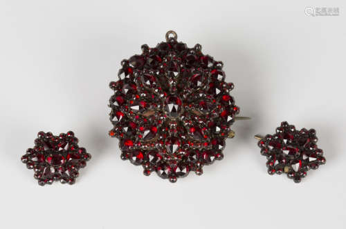 A Bohemian garnet pendant brooch of shaped oval form, the back glazed with a locket compartment,
