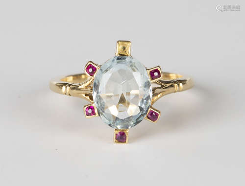 A gold ring, mounted with an oval cut aquamarine within a surround of five rubies in rectangular