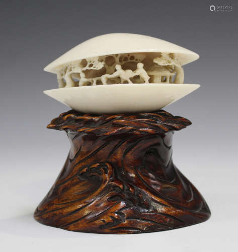 A Japanese carved ivory clam's dream okimono, Meiji period, the slightly open shell revealing a