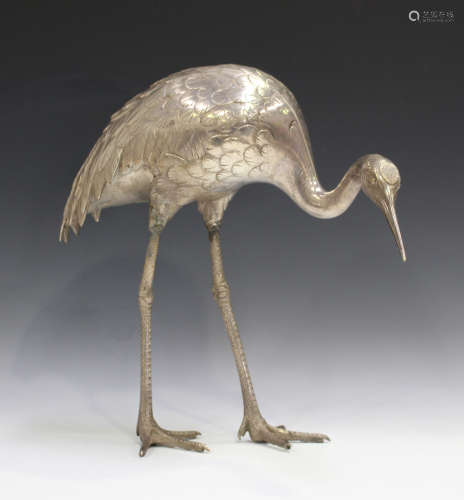 A Japanese silvered bronze model of a red-capped crane, Meiji period, standing with lowered head,