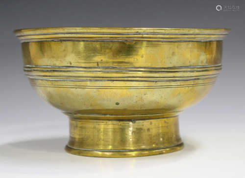 A Chinese polished bronze circular footed bowl, Qing dynasty, the body with horizontal ribbed girdle