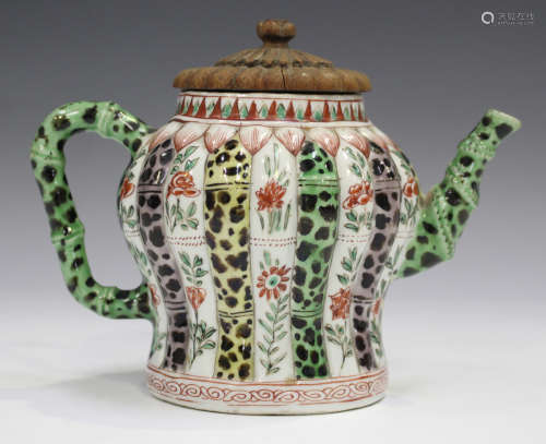 A Chinese famille verte porcelain teapot, Kangxi period, with carved wood cover, the baluster body