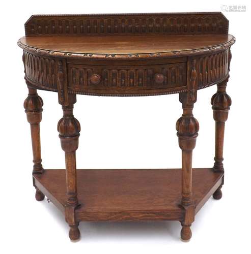 Carved oak demi lune side table, with raised back and single freize drawer, raised upon carved